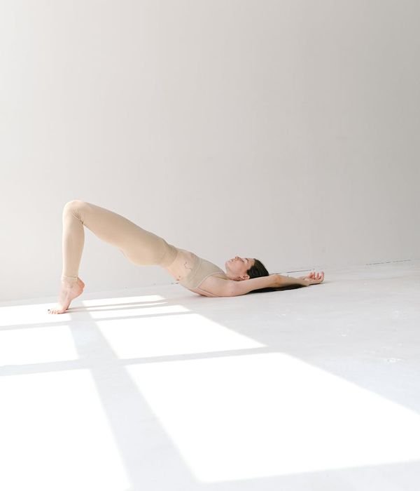 Woman in a calm yoga pose against a light blue background.